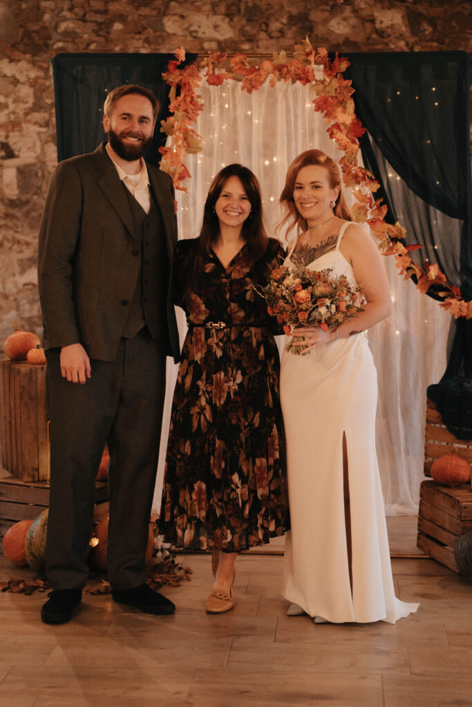 Hochzeitsplanerin Romina Blume lacht gemeinsam mit dem Brautpaar bei ihrer Herbsthochzeit in der Scheune.