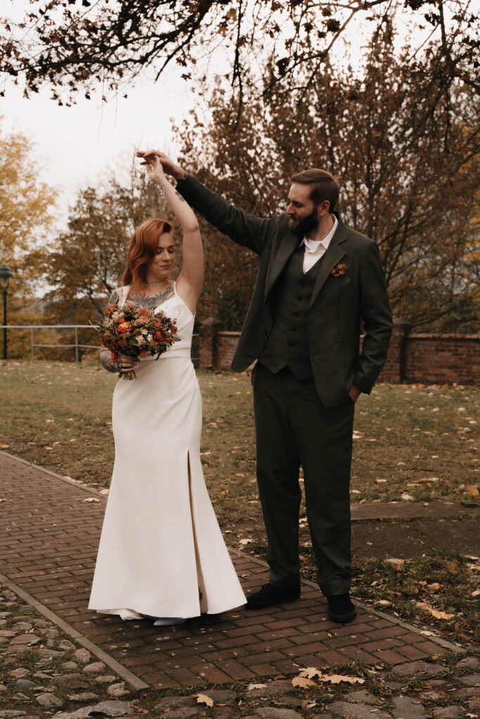 Brautpaar tanzt entspannt und ungezwungen im Außenbereich einer Herbsthochzeit in Brandenburg.
