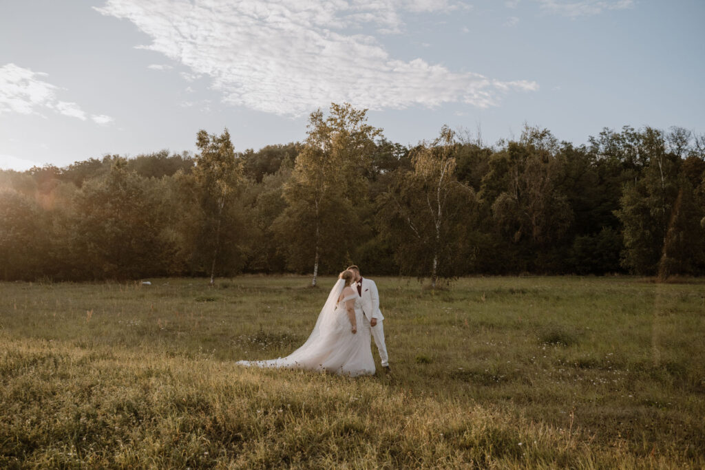 Brautpaar bei einer sommerlichen Landhochzeit in Brandenburg auf einer Wiese im Abendlicht